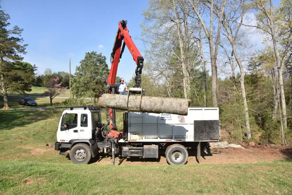 Grapple truck lifting a log on a residential job