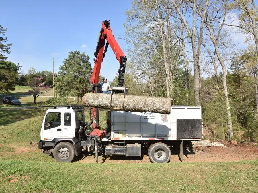 Grapple truck lifting a log on a residential job